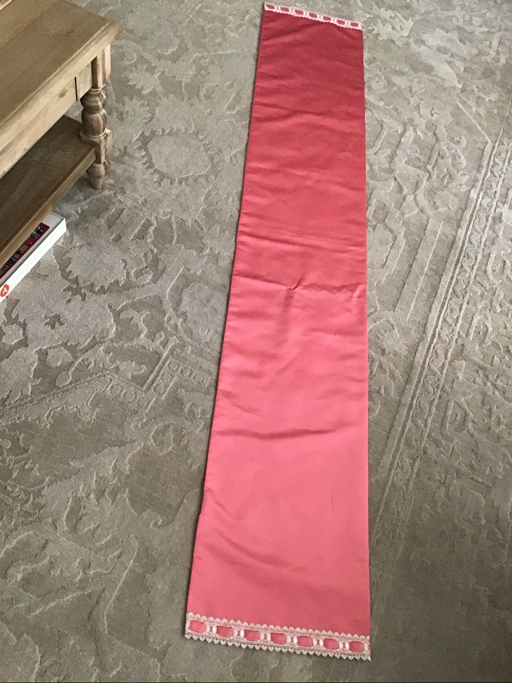 Table runner features a decorative white lace and ribbon trim